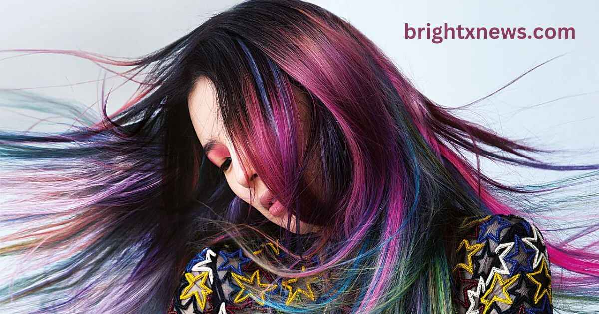 A woman with vibrant calico hair color trend is blowing her hair, showcasing a dynamic and colorful hairstyle.