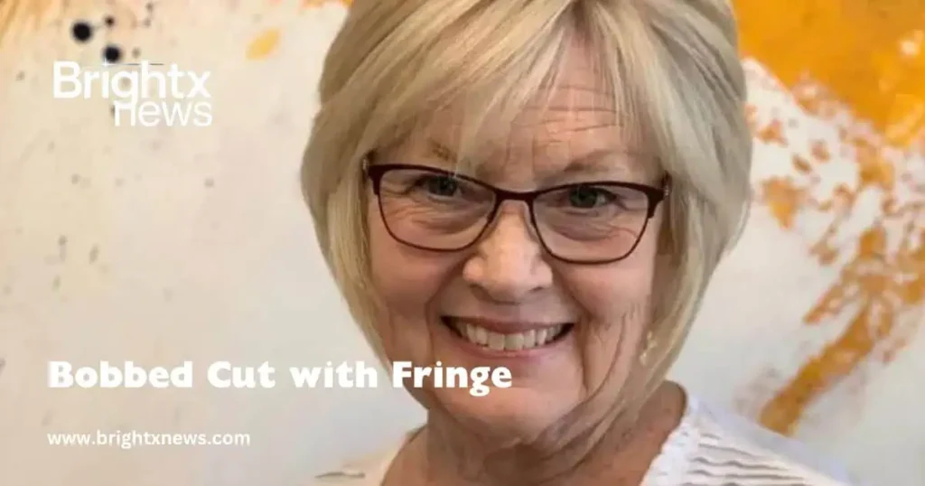  A woman with glasses and a smile, showcasing her stylish bobbed cut with fringe.