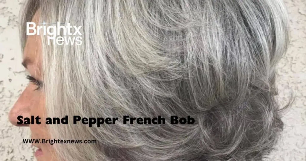 A woman with gray hair styled in a Salt and Pepper French Bob against a clean white background.