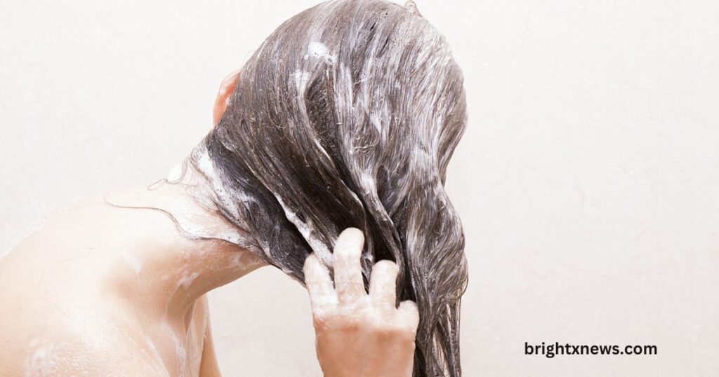 A woman washes her hair with a brush, exploring what hair type is ideal or suitable for native shampoo use.