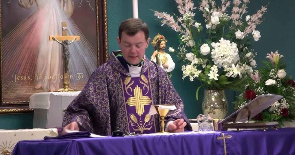 A priest in purple robes sits at a table, embodying the essence of spirituality and tradition in the context of who-is-adam-kotas.